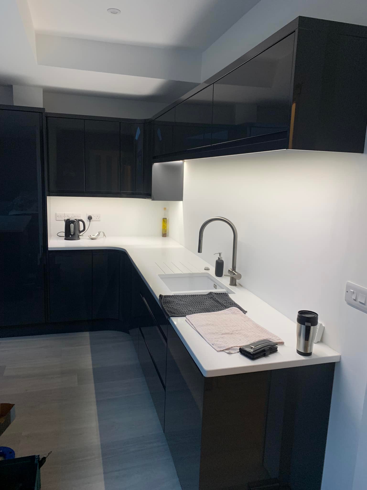Black kitchen units with LEDS underneath illuminating the worktop